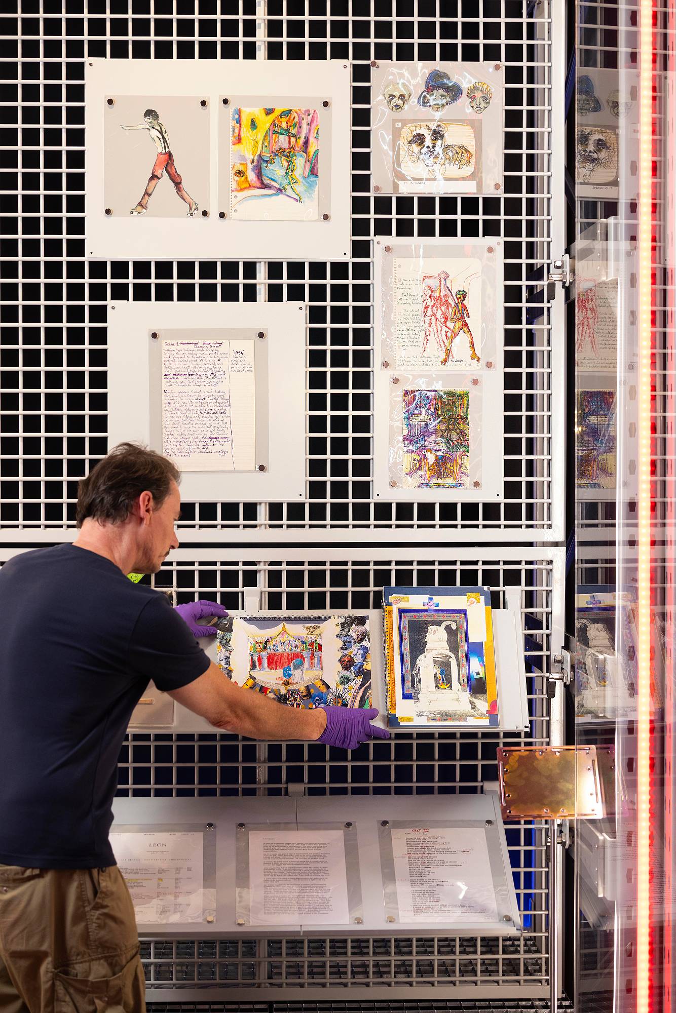 A V&A Technician applies finishing touches to a display of David Bowie’s ‘Unrealised Projects’. Credit: David Parry for the V&A
