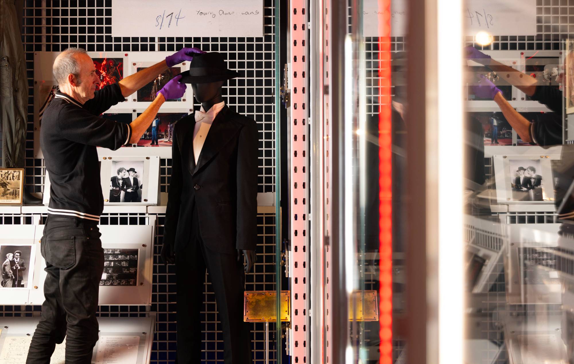 A V&A Technician adjusts the suit Bowie wore for the 1975 Grammy Awards, made by Jan Girard. Credit: David Parry for the V&A